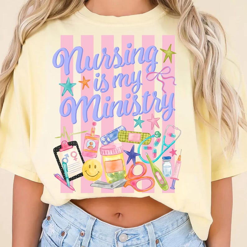 May include: Yellow t-shirt with the text "Nursing is my Ministry" in blue script, accented with stars and medical-themed illustrations. The design includes a clipboard, pills, a stethoscope, and a syringe.