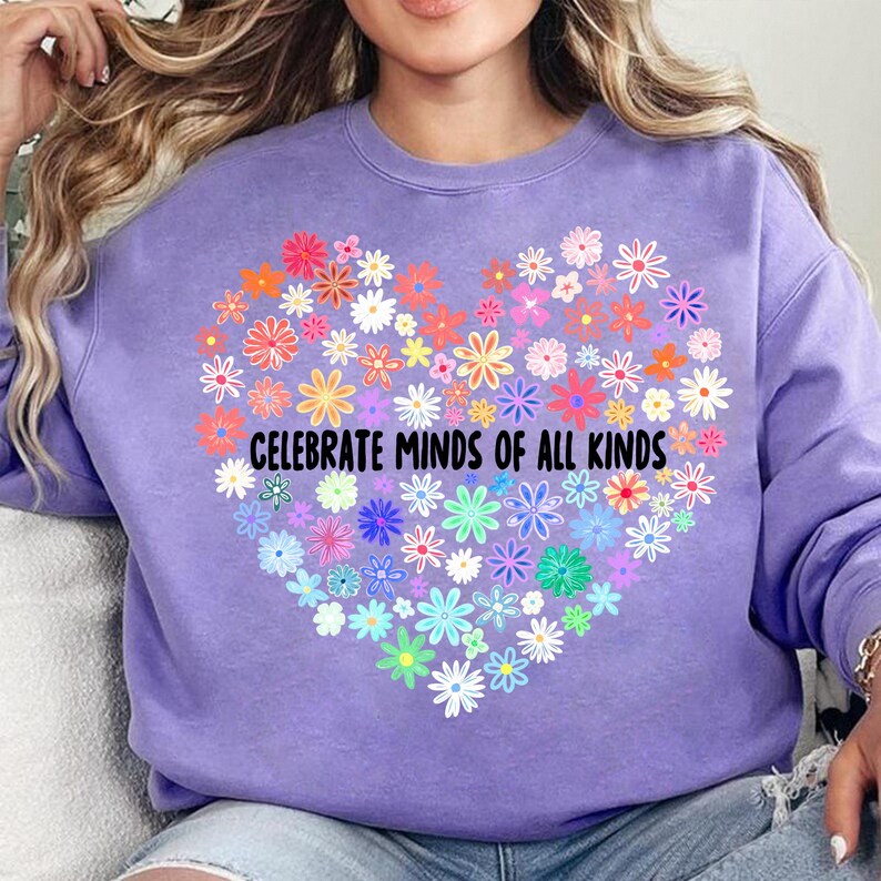 May include: Purple sweatshirt with a rainbow heart made of flowers and the text "Celebrate Minds of All Kinds".