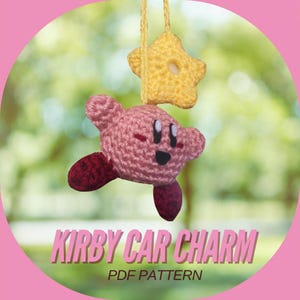May include: A pink and red crocheted Kirby character with a yellow star hanging from it. The text "KIRBY CAR CHARM PDF PATTERN" is below the character.
