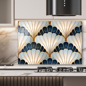 May include: A decorative kitchen splashback with a repeating fan-shaped pattern. The design incorporates white, navy blue, and gold colours. The splashback is installed above a countertop with a hob.