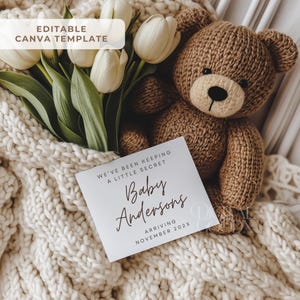 May include: A brown knitted teddy bear sits next to a white card with the text "Baby Andersons Arriving November 202X". White tulips and a cream-colored knitted blanket complete the scene. The words "Editable Canva Template" are in the top left corner.