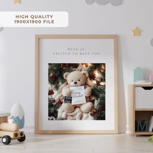 K&ouml;nnte beinhalten: Ein gerahmter Druck mit einem Teddyb&auml;ren, der eine Karte mit einem Ultraschallbild h&auml;lt. Auf der Karte steht "I'll be home for Christmas" und "Baby Mitchell". Der Rahmen ist aus hellem Holz, und der Hintergrund umfasst Gr&uuml;n und Beeren.