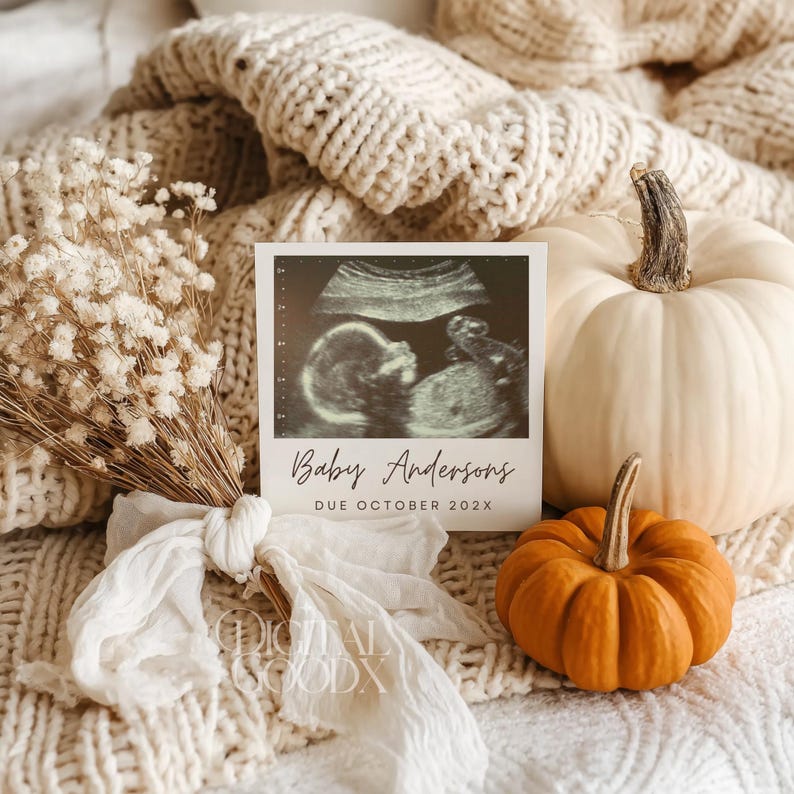K&ouml;nnte beinhalten: Eine Schwangerschaftsank&uuml;ndigung mit einem Ultraschallbild und dem Text "Baby Andersons DUE OCTOBER 202X". Die Szene umfasst einen wei&szlig;en K&uuml;rbis, einen orangefarbenen K&uuml;rbis und einen Strau&szlig; Trockenblumen, alles auf einer cremefarbenen Strickdecke.