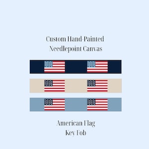 May include: Custom hand-painted needlepoint canvas key fobs featuring the American flag. The fobs are displayed in three color variations: navy blue, beige, and light blue. Each fob has a rectangular shape with a flag design.