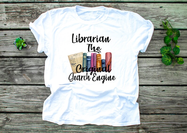 May include: White t-shirt with the text "Librarian The Original Search Engine" in black. The text is accompanied by a watercolor illustration of a stack of books.