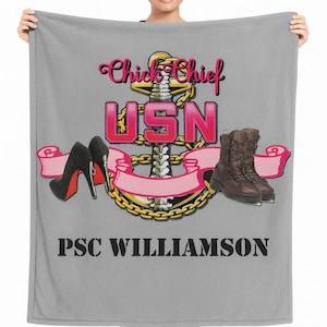 May include: A gray blanket featuring a design with the text "Chick Chief USN" above an anchor, high heels, and boots. The text "PSC WILLIAMSON" is printed below the design.