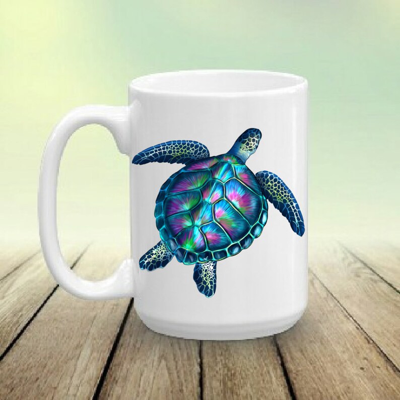 May include: White ceramic coffee mug featuring a colourful sea turtle design. The turtle has a blue, green and purple shell with black outlines.