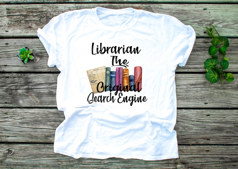 May include: White t-shirt with the text "Librarian The Original Search Engine" in black. The text is accompanied by a watercolor illustration of a stack of books.