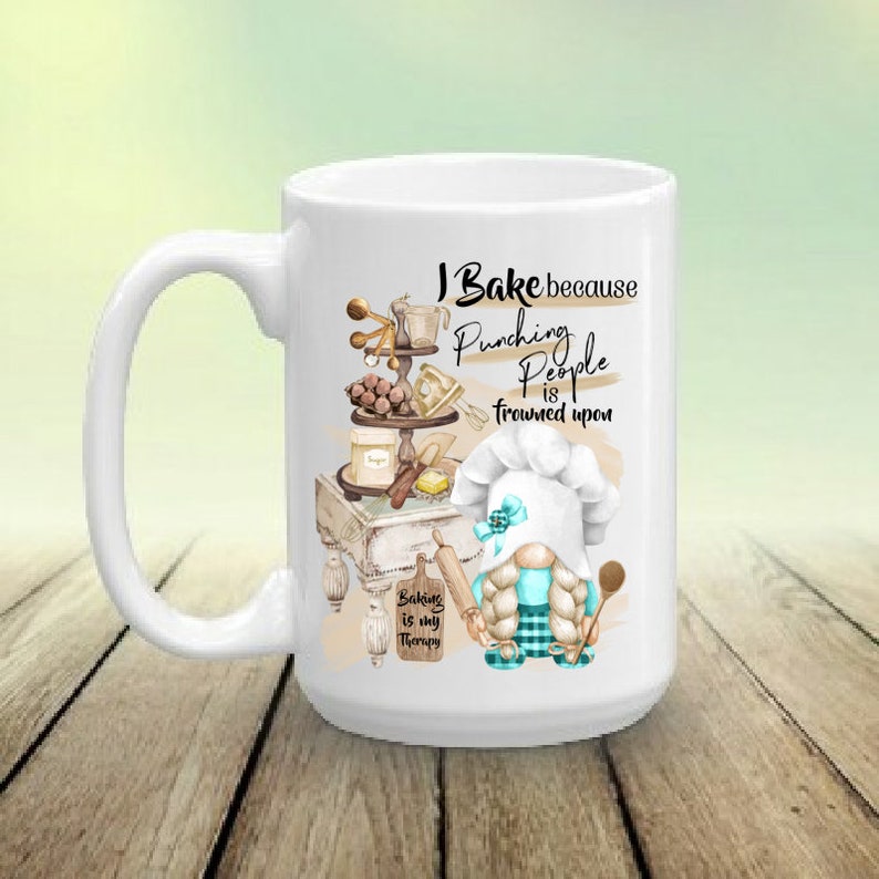 May include: White ceramic mug with a whimsical design featuring a gnome chef and baking-themed illustrations. The mug has the text "I Bake because Punching People is frowned upon" and "Baking is my Therapy".