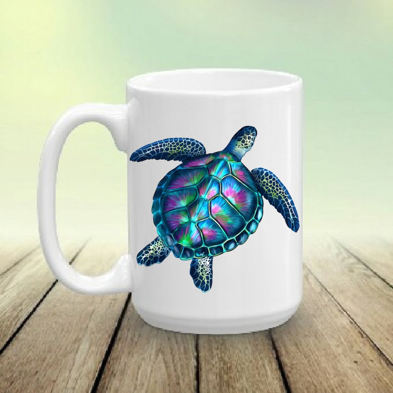 May include: White ceramic coffee mug featuring a colourful sea turtle design. The turtle has a blue, green and purple shell with black outlines.