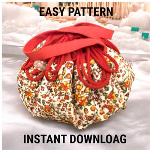 May include: A round, floral fabric pouch with a red drawstring closure and handle. The pouch features a cream background with orange and yellow flower patterns. The text "EASY PATTERN" and "INSTANT DOWNLOAD" are displayed.