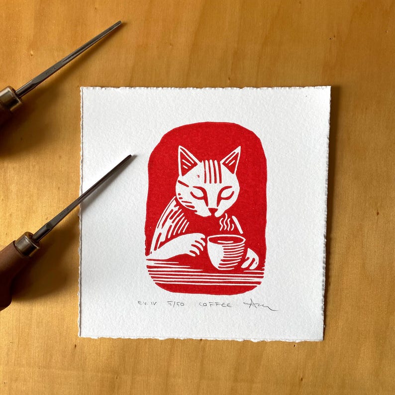 Cat drinking a cup of coffee, red ink print. Katze trinkend eine Tasse Kaffee, roter Tintendruck. Chat buvant une tasse de café, estampe à l'encre rouge. Gatto che beve una tazza di caffè, stampa a inchiostro rosso. Gato tomando una taza de café, grabado en tinta roja. Linocut, linoprint, lino cut, linogravure, relief print. Linolschnitt, Linodruck, Linogravur, Hochdruck. Linogravure, gravure sur linoléum, estampage en relief. Linoleografia, stampa su linoleum,  Linóleo, linograbado