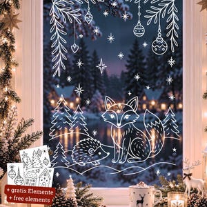 May include: A white window decal featuring a fox and a hedgehog surrounded by pine trees, hanging ornaments, and stars. The design includes additional smaller sticker sheets with trees, houses, and ornaments labeled with the text + free elements.