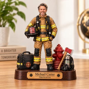 Może przedstawiać: Figurka strażaka na drewnianej podstawie z tabliczką Michael Carter FIREFIGHTER. Postać ma na sobie beżowy mundur z żółtymi odblaskowymi pasami i trzyma czarny hełm z napisem 27 CARTER. W zestawie czarna torba, czerwony hydrant i toporek.