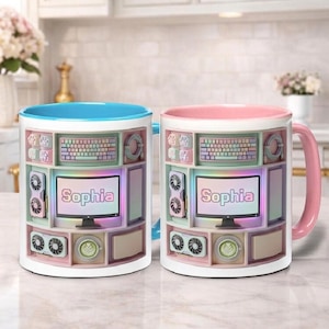May include: Two ceramic mugs with a computer-themed design. One mug has a blue interior and handle, the other has a pink interior and handle. Each mug features a computer monitor with the name "Sophia" and other computer components.