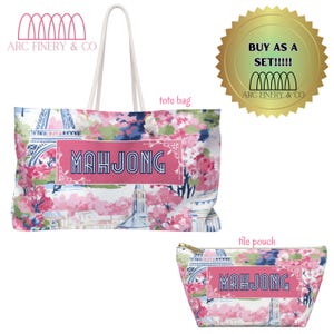 May include: A white tote bag and a matching tile pouch with a pink floral pattern featuring a Parisian Eiffel Tower design. The bag and pouch have the text "MAHJONG" in a pink rectangle.