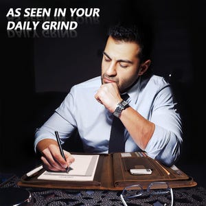 May include: A brown leather portfolio with a zipper closure and a pen holder. The portfolio is open and has a lined notepad inside. A person is writing in the notepad with a black pen.