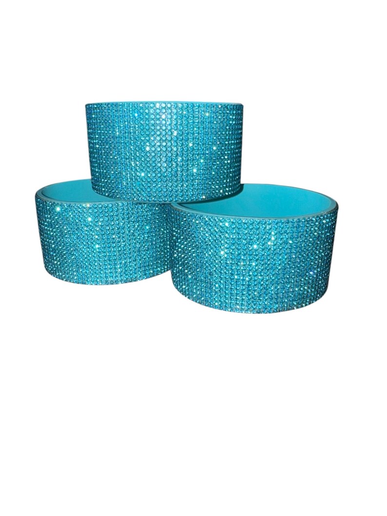 Puede incluir: Tres posavasos turquesas. Cada posavasos es cil&iacute;ndrico con un exterior brillante, similar a pedrer&iacute;a y un interior turquesa liso. Los posavasos est&aacute;n apilados en forma triangular sobre un fondo blanco.