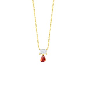 May include: A gold chain necklace featuring a horizontal rectangular clear gemstone pendant with a smaller, dangling pear-shaped orange gemstone suspended directly beneath it, creating a layered and delicate drop design on a thin metal link chain.