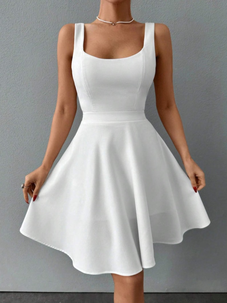 May include: A white sleeveless dress with a square neckline and a fitted bodice. The skirt is a-line and falls to just above the knee.