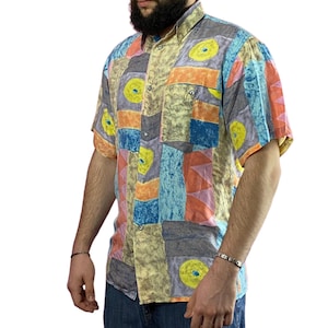 May include: A short-sleeved button-down shirt with a colorful geometric pattern. The shirt is made of a lightweight fabric and has a relaxed fit.