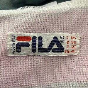 May include: White Fila label with red, blue, and black text. The label says "Fila" and "Made in Italy". It also has size information: "I 56", "D 56", "F 46", and "USA 46".