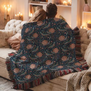 Navy blue throw blanket with a repeating pattern of snails and flowers.