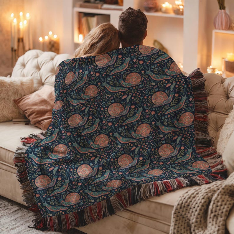 Navy blue throw blanket with a repeating pattern of snails and flowers.