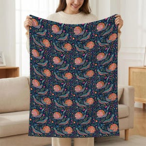 Dark blue blanket with a colorful snail and floral pattern.