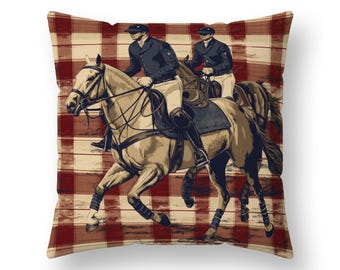 May include: Throw pillow featuring an illustration of two riders on horseback, set against a red and cream plaid background. The riders are dressed in dark jackets and riding gear. The horses are a light brown color.