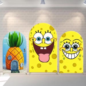 May include: Three yellow SpongeBob SquarePants themed backdrops. One depicts a pineapple house, the others show SpongeBob's face with different expressions. The backdrops are arched at the top and have metal stands.