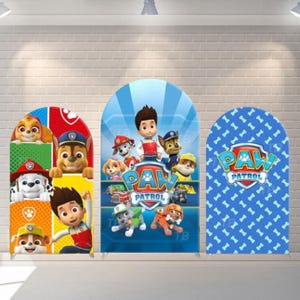Könnte beinhalten: Drei bogenförmige Hintergrundbanner mit Figuren aus der Zeichentrickserie Paw Patrol. Die Banner sind in Rot, Blau und Weiß gehalten und zeigen Bilder der Charaktere und das Paw Patrol-Logo. Das Banner rechts hat einen blauen Hintergrund mit weißen Pfotenabdrücken.