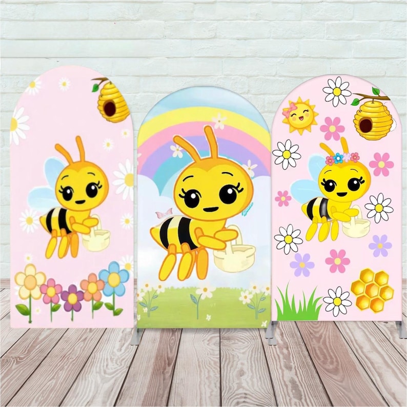 Puede incluir: Tres paneles arqueados con abejas de dibujos animados. Cada abeja es amarilla y negra, sosteniendo una cesta. Los fondos incluyen una escena floral rosa, un arco&iacute;ris y un d&iacute;a soleado con un panal. Los paneles est&aacute;n sobre soportes met&aacute;licos.