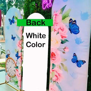 K&ouml;nnte beinhalten: Drei dekorative Paneele mit Blumen- und Schmetterlingsmotiven. Die Paneele zeigen rosa Rosen, blaue Schmetterlinge und eine Taschenuhr. Auf den Paneelen steht "Back", "White Color" und "Vibrant colors".