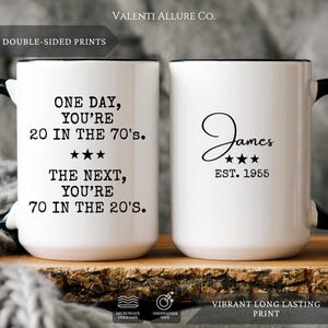 May include: White ceramic mug with a black handle and rim. One side reads "ONE DAY, YOU'RE 20 IN THE 70'S. THE NEXT, YOU'RE 70 IN THE 20'S." The other side says "James EST. 1955." The mug is double-sided and microwave and dishwasher safe.