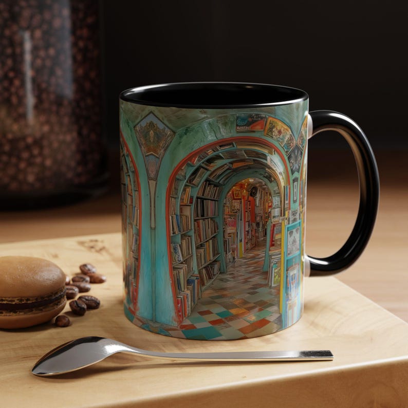 May include: A ceramic coffee mug with a black interior and handle. The mug features a detailed illustration of a library hallway with bookshelves and arched doorways. The color palette includes teal, orange, and brown tones.