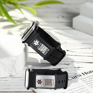 Könnte beinhalten: Zwei schwarze medizinische Notfall-Armbänder mit silbernen Zifferblättern. Jedes Band hat eine silberne Platte mit einem medizinischen Symbol, den Worten "HEALTH INFO", einem QR-Code und den Worten "SCAN ME".