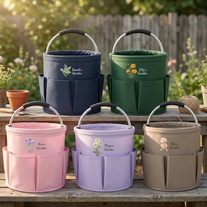 May include: Five cylindrical garden tool bags with metal handles and exterior pockets. The bags are navy, dark green, light pink, lavender, and beige. Each features a floral illustration and text: Sarah's Garden, Lily's Garden, Ava's Garden, Maya's Garden, and Mia's Garden.