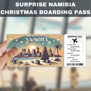 May include: A Christmas-themed boarding pass with a festive illustration of a city skyline with a Christmas tree in the foreground. The text reads "You're going to Namibia" and includes a boarding pass with the passenger name "Emily Parker", departure date "24 Dec 2024", return date "12 Jan 2025", and message "Surprise! Merry Christmas".