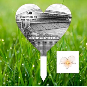 May include: A heart-shaped memorial stake featuring a black and white stadium image. Text reads "DAD WE'LL LOVE YOU AND MISS YOU ALWAYS" and "YOU'LL NEVER WALK ALONE." A small square features the text "Forever in our Hearts."