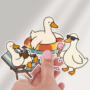 May include: A collection of stickers featuring cartoon ducks enjoying summer. One duck is in a pool float, another is drinking from a coconut, and the third is eating ice cream and wearing sunglasses. The stickers have a white background and black outlines.
