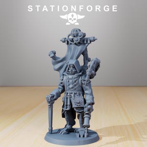 May include: A gray miniature figure of a character in a military-style coat, hood, and mask, holding a staff and a mechanical device. The figure has a smaller figure on its back. The text "STATIONFORGE" is at the top.
