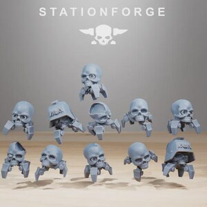May include: A collection of gray skull-shaped miniatures with robotic legs. Some skulls have helmets. The word "STATIONFORGE" is at the top, along with a skull and crossbones logo. These miniatures are likely for tabletop gaming or model building.