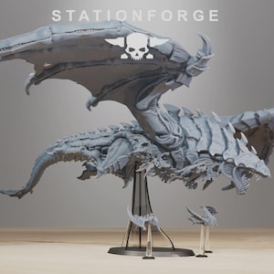 Puede incluir: Un modelo gris detallado de un dragón con grandes alas, garras afiladas y una boca amenazante. El modelo está soportado por un soporte negro. El texto "STATIONFORGE" y un logotipo de calavera son visibles.