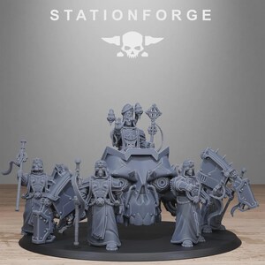 Może przedstawiać: Szary model miniaturowy procesji religijnej, z postaciami w szatach i hełmach, z dużym pojazdem w kształcie czaszki pośrodku. Tekst "STATIONFORGE" i logo czaszki u góry.