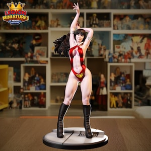Puede incluir: Figura detallada de una mujer con un body rojo y dorado y botas negras, con los brazos levantados. La figura tiene pelo largo y oscuro y está de pie sobre una base redonda gris. El logotipo "LEGION MINIATURES 3D PRINTING DESIGNS" es visible.