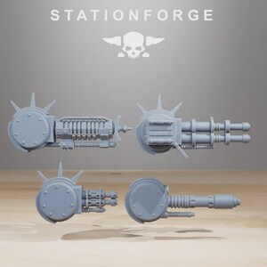 May include: Four gray miniature weapon models, including a gatling gun and other mechanical components. The models are arranged against a neutral background. The text "STATIONFORGE" is at the top.