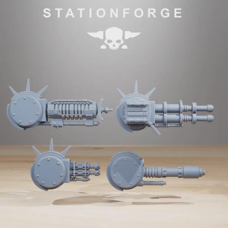 May include: Four gray miniature weapon models, including a gatling gun and other mechanical components. The models are arranged against a neutral background. The text "STATIONFORGE" is at the top.