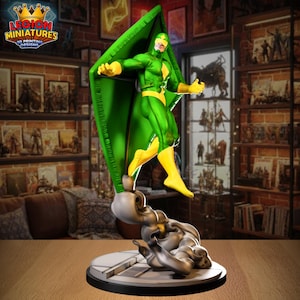 May include: A green and yellow superhero figurine with a large green wing-like structure. The figure is posed mid-stride on a detailed base. The figurine is a 3D printed design, as indicated by the logo in the top left corner.