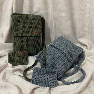 May include: Two crocheted bags, one green and one blue, with a smaller crocheted pouch in front of each. The bags have leather labels that say "handmade".